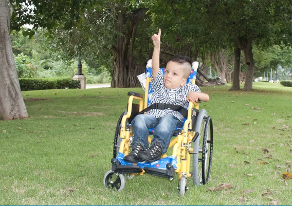 Niño sonriendo en silla de ruedas infantil - servicio de renta